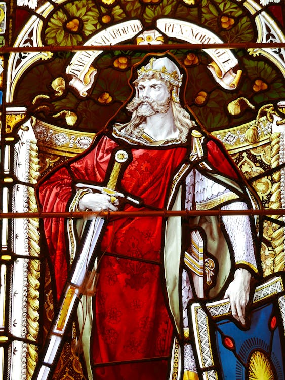 Intricate stained glass depicting a historical king in a cathedral capturing the regal authority and enduring legacy the King of Wands represents