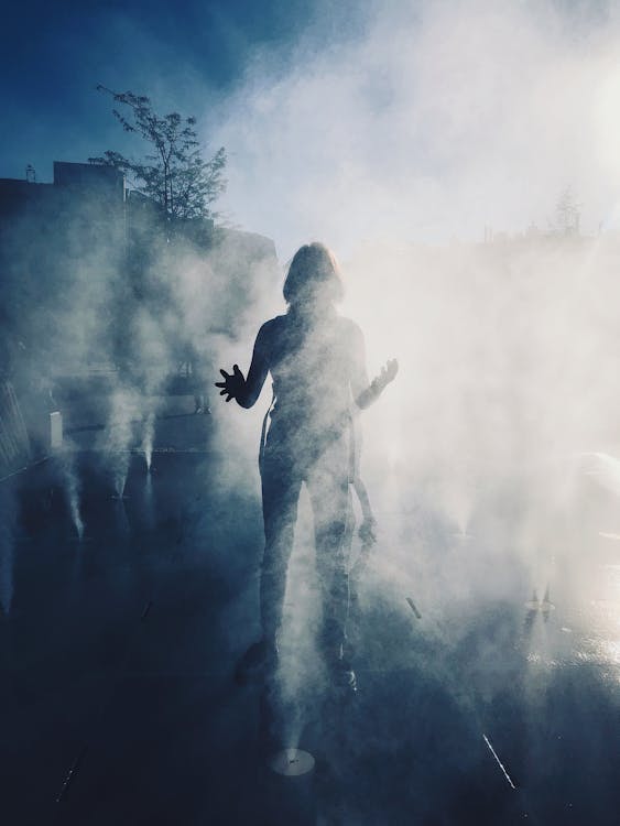 A person standing amidst dense fog outdoors creating a mysterious ethereal scene that captures the confusion and dreamlike uncertainty of the Seven of Cups