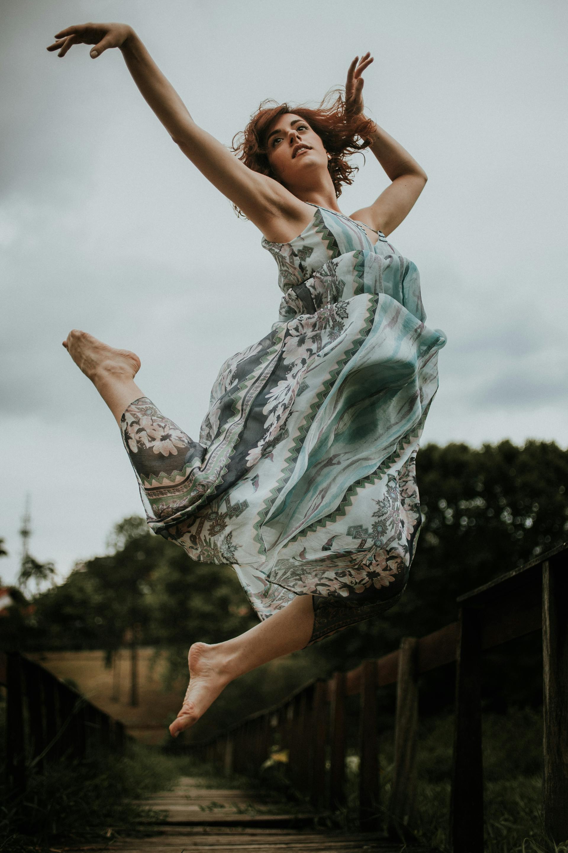 A graceful dancer captured mid-leap in an outdoor setting radiating the energy and completion of The World card