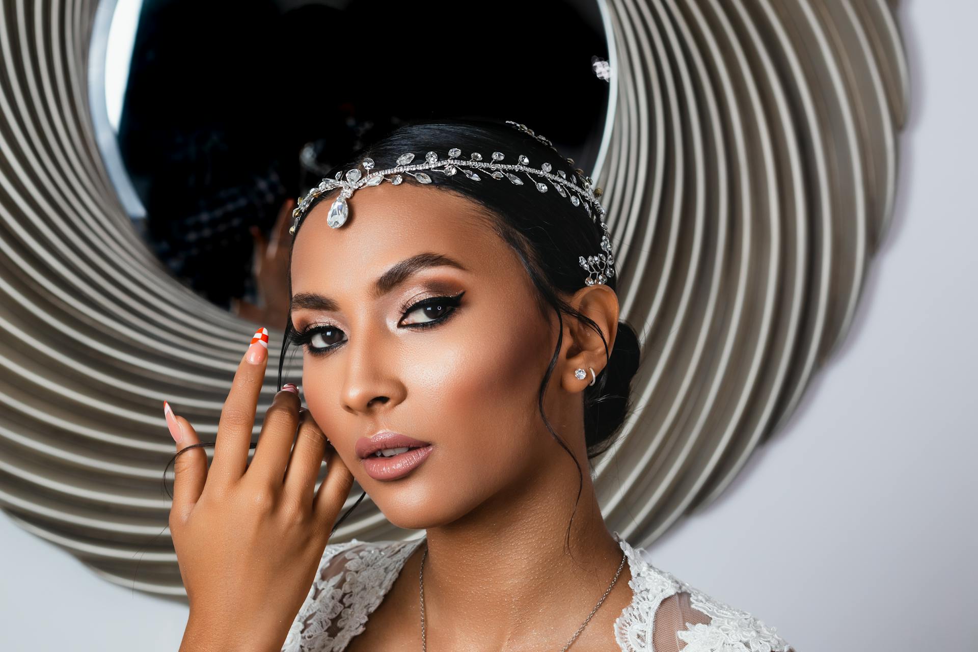 Portrait of a woman wearing elegant jewelry in front of a decorative mirror representing Venus themes of self-worth beauty and deeper values