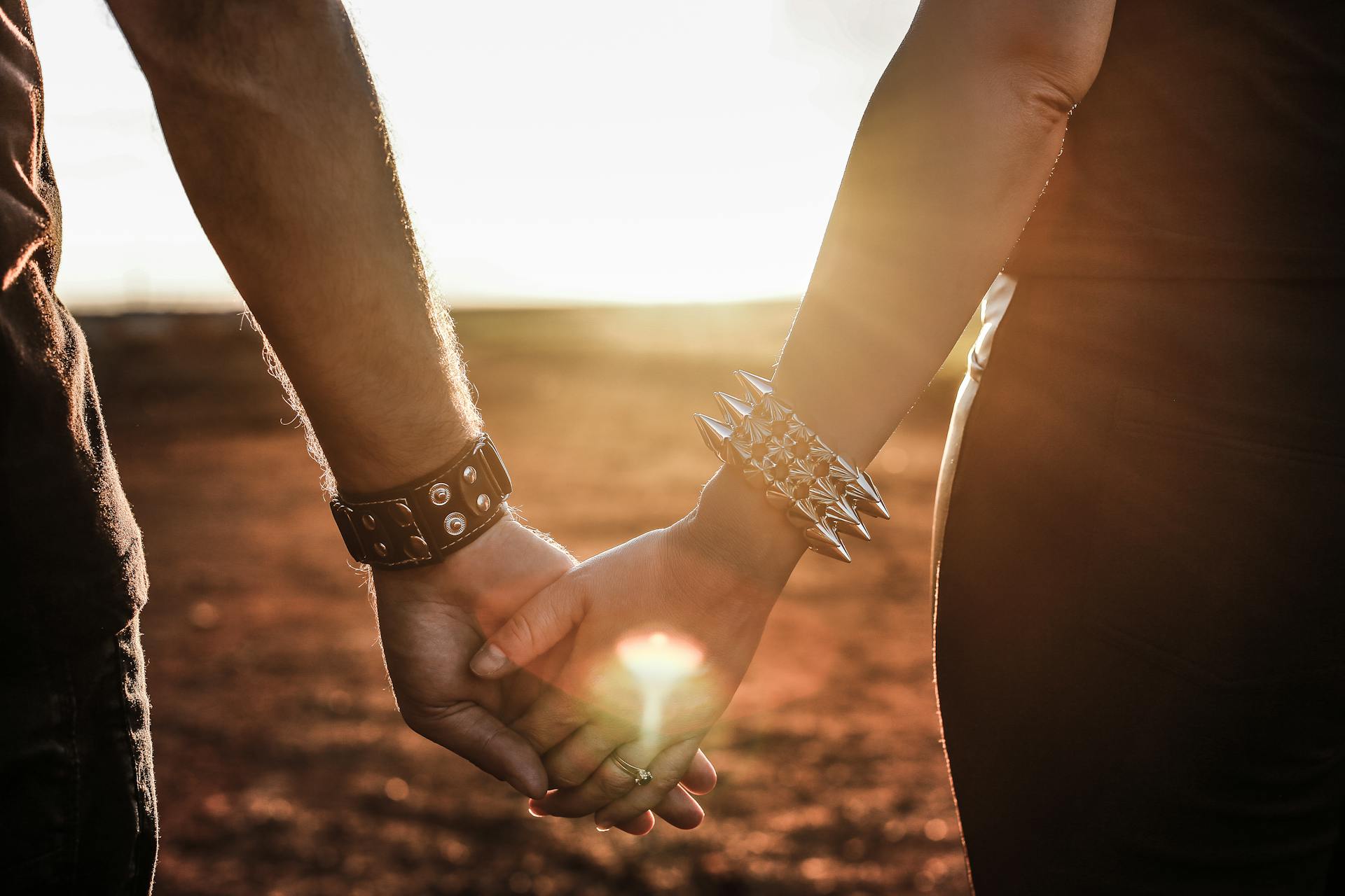 Close-up of a couple holding hands at sunset representing Venus themes of love and connection in astrology