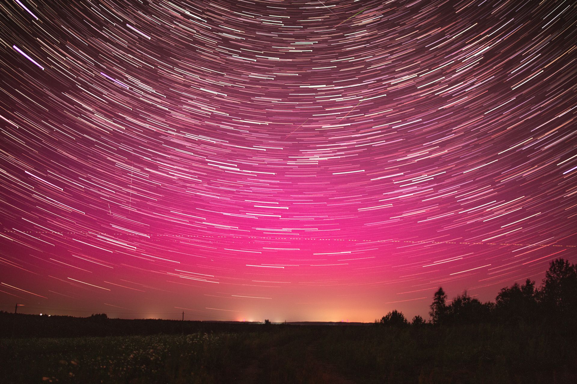 A deep starry night sky washed in soft pink light, evoking the planet Venus