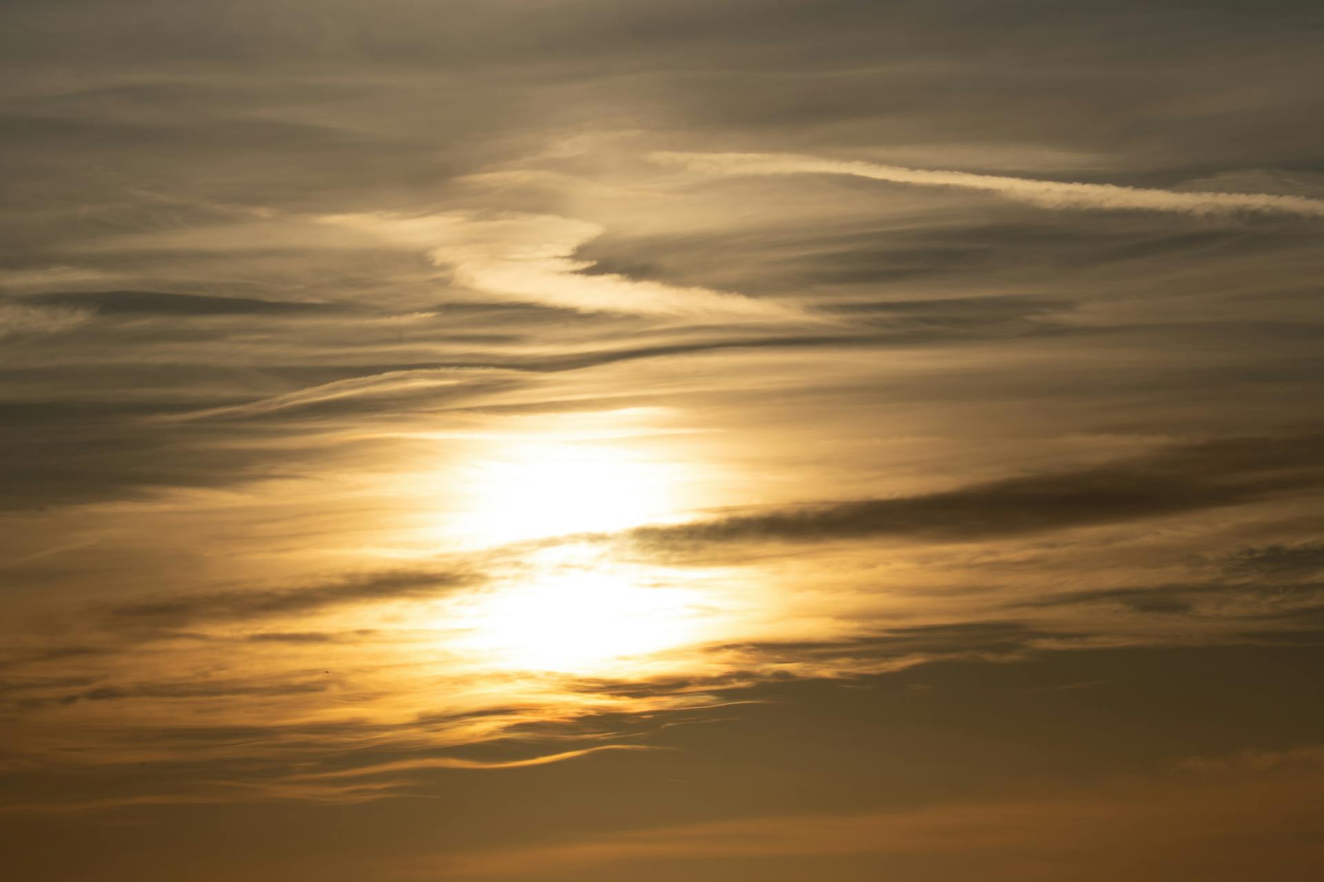 Golden sunset with dramatic cloud formations on a serene sky at the horizon