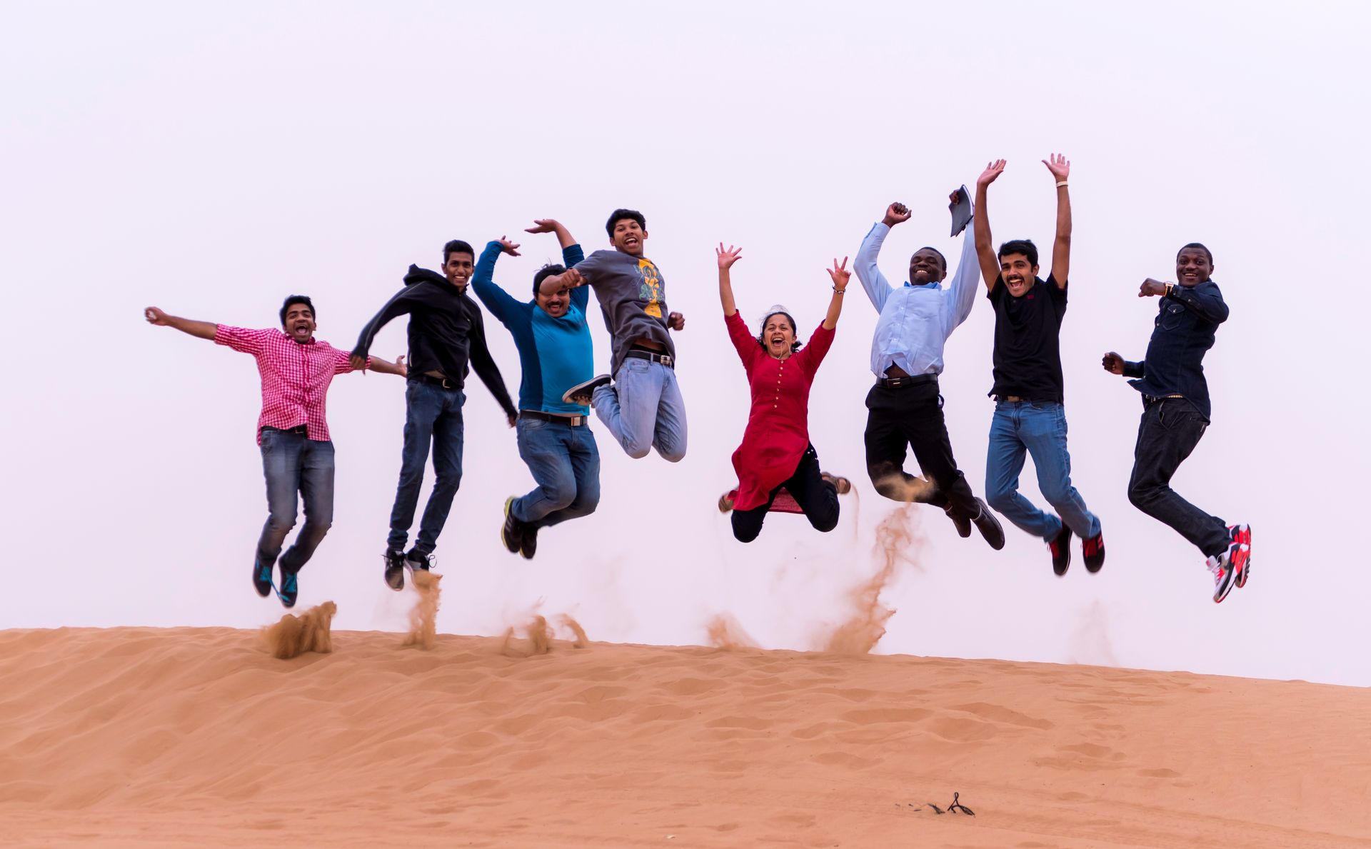 A joyful group of friends jumping together outdoors, capturing the spontaneous energy of compatible fire and air zodiac signs