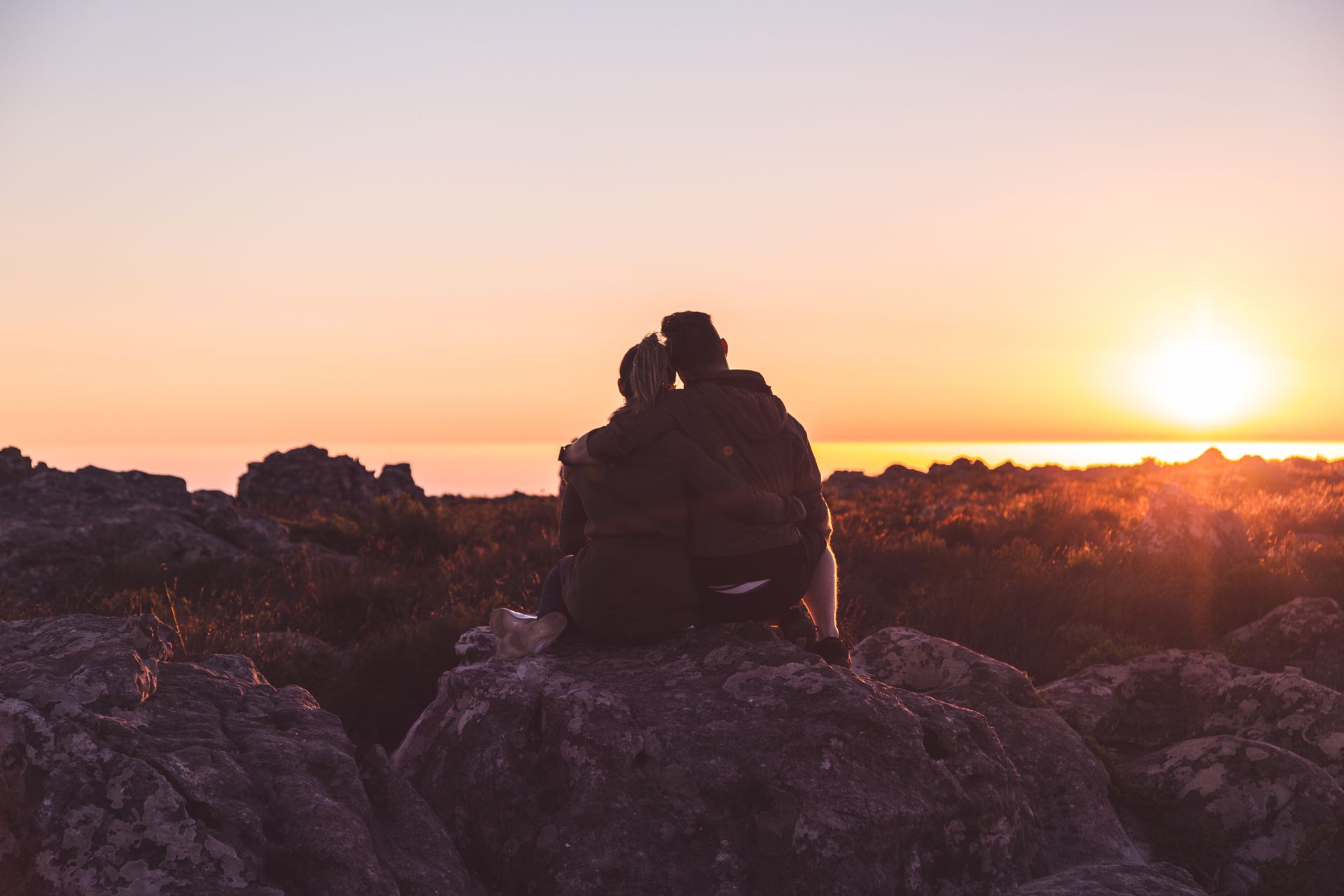 Two friends embracing warmly at sunset, representing the deep loyalty between compatible water and earth zodiac signs