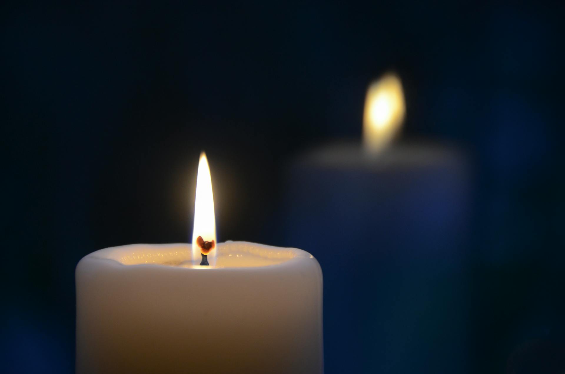 A close-up of a burning candle with a soft warm glow creating an intimate and tranquil atmosphere