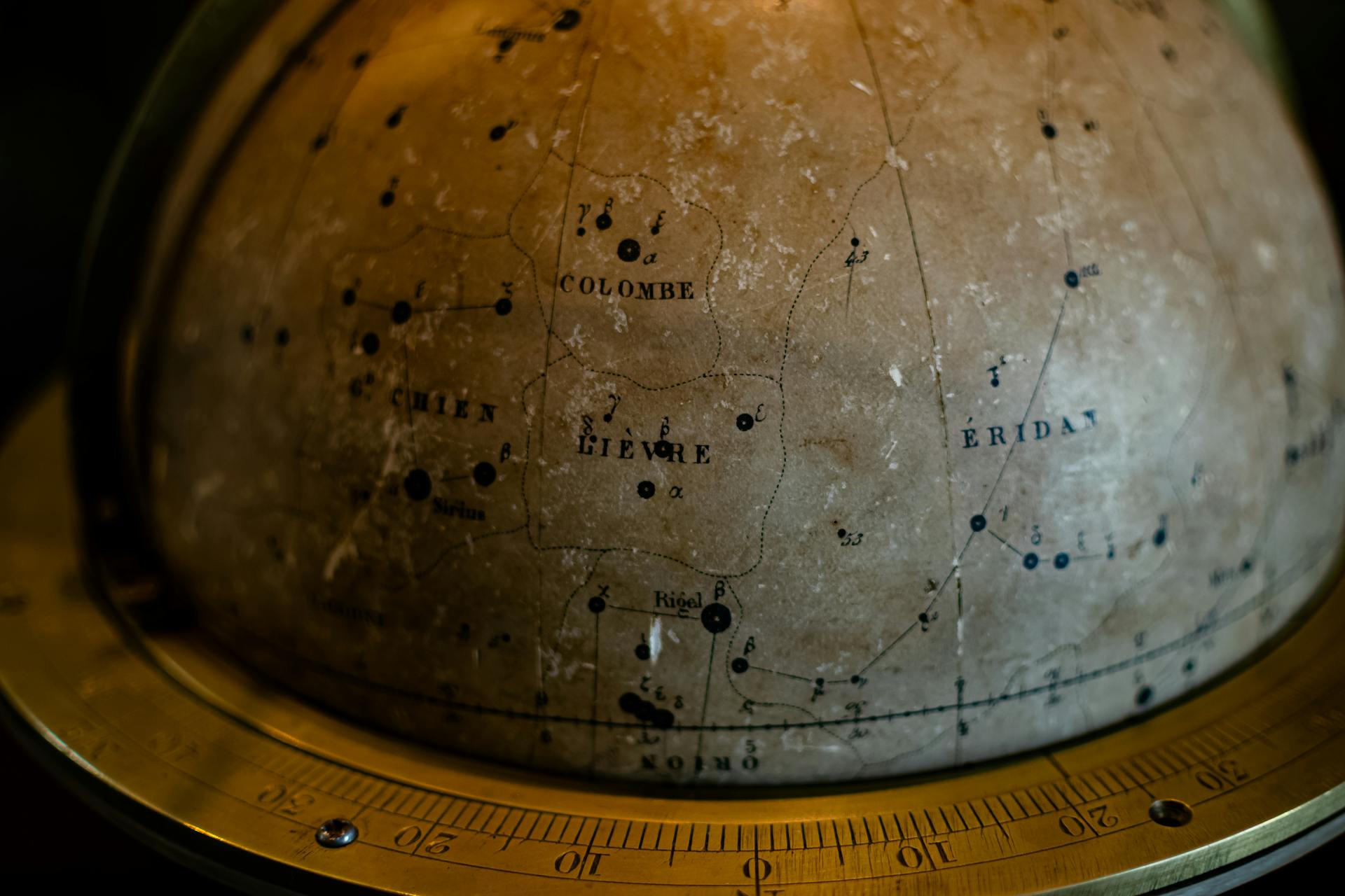 Close-up of an antique celestial globe featuring constellation engravings representing the mapping of cosmic cycles through time